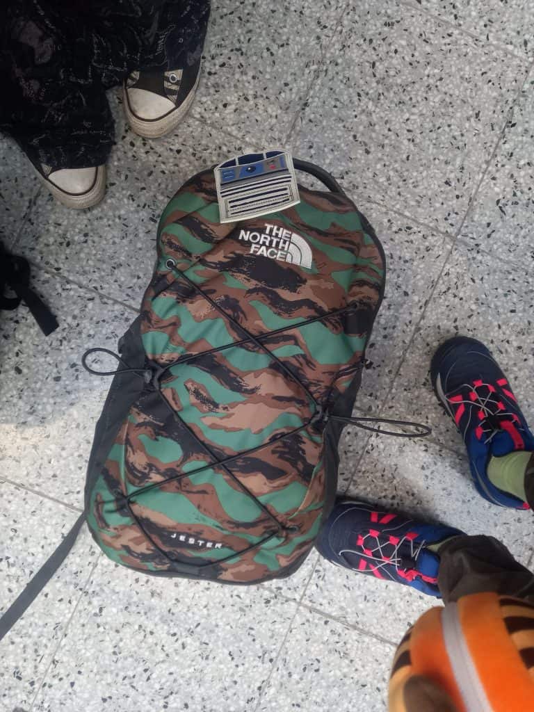 North Face camo style backpack sits on floor of airport