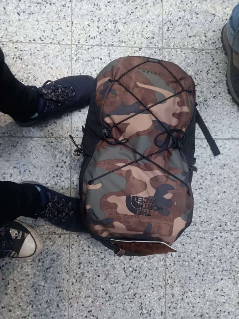 North Face camo style backpack sits on floor of airport