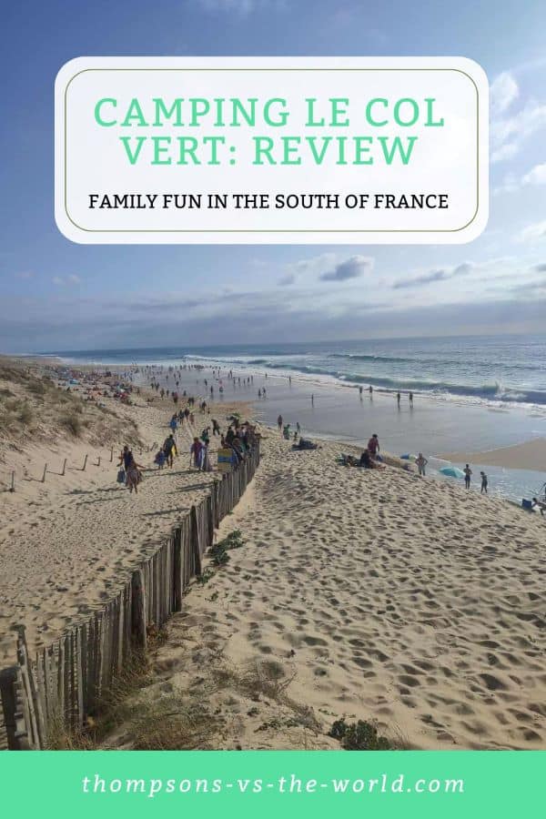 Vibrant beach scene in the South of France with a sandy shoreline, gentle waves, and people enjoying the sun, framed by wooden fences and dunes. Text overlay reads "CAMPING LE COL VERT: REVIEW - FAMILY FUN IN THE SOUTH OF FRANCE" in green and white. Perfect for families planning a camping trip! Save this pin to your Pinterest board for later reference.