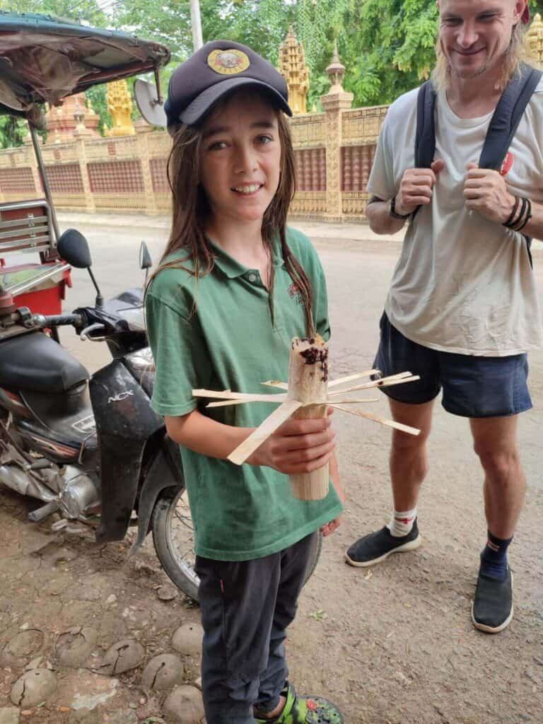 Boy stands with portion of bamboo sticky rice in Battambang, Cambodia