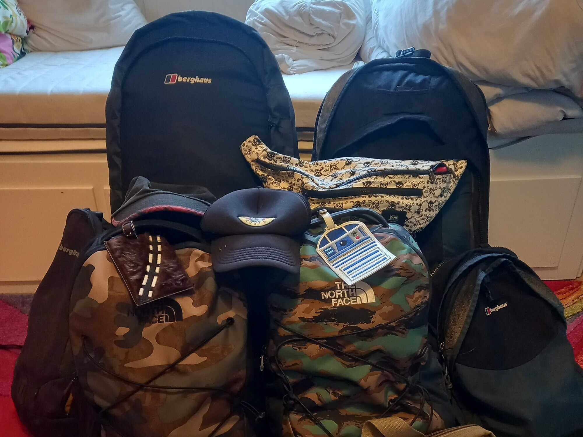 Four backpacks stand fully packed in a bedroom ready for adventure!