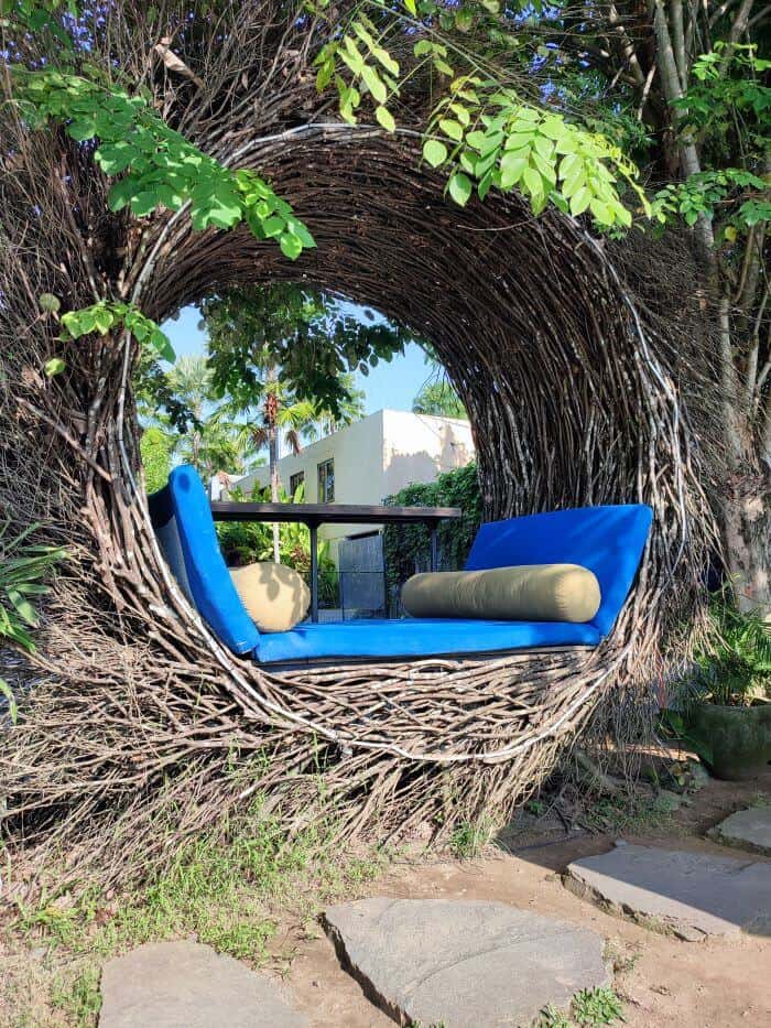 A cozy woven nest lounge area with blue cushions at Titi Batu Ubud, surrounded by greenery, highlighted in this Titi Batu Ubud review.