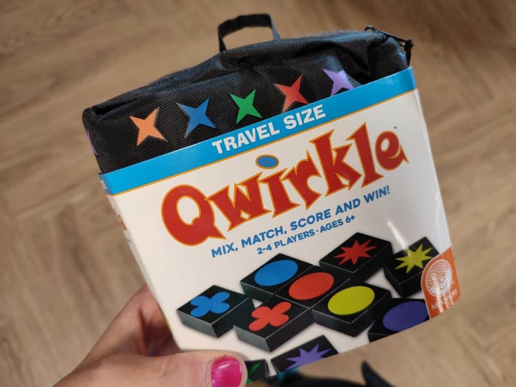 Travel size Qwirkle game in black pouch with different coloured stars printed on it.