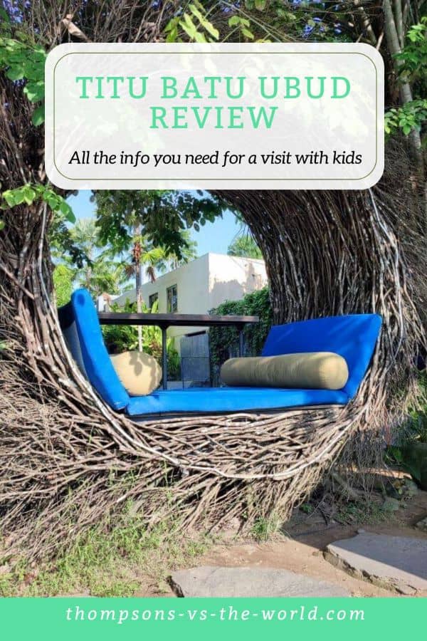 A cozy woven nest lounge with blue cushions at Titi Batu Ubud, framed by lush greenery, with text overlay reading "Titi Batu Ubud Review: All the info you need for a visit with kids" - pin this for your next family trip to Bali!