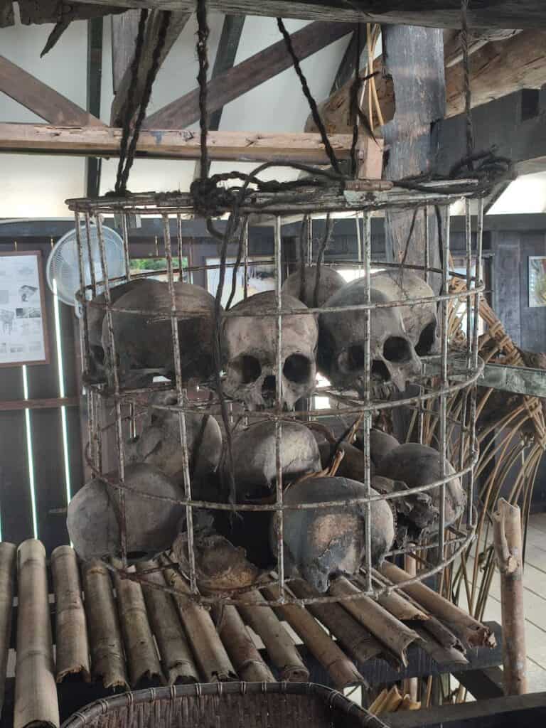 Several human skulls hang within a large metal cage inside a traditional longhouse at Annah Rais outside Kuching, Borneo.